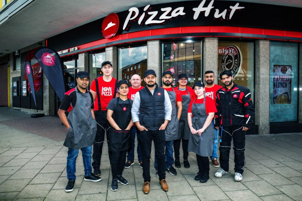 Closed Pizza Hut storefront with shutters down illustrating Pizza Hut Job Losses UK.